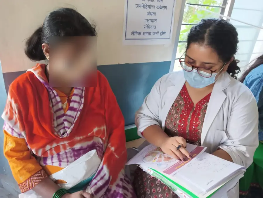 Sanchita counselling a mother on nutrition; the mother's face is blurred for privacy